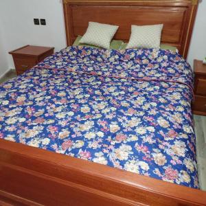 a bed with a blue floral quilt on it at Imouzzar kandar in Imouzzer du Kandar