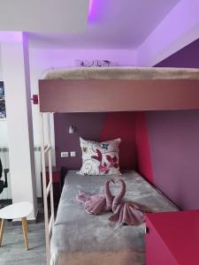a bedroom with a bunk bed with purple walls at Бутик хотел ресторант брасери Сажитариус in Kyustendil