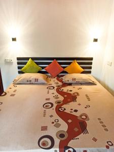 a bedroom with a large bed with colorful pillows at Maneesha Guest House in Weligama