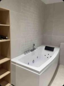 een wit bad in een badkamer met planken bij Magnifique maison tout confort in Marseille