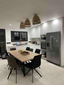 a kitchen with a table with chairs and a refrigerator at Magnifique maison tout confort in Marseille