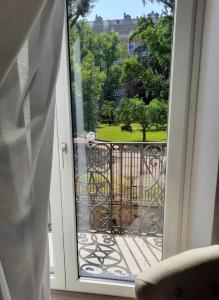 an open door to a balcony with a view of a park at ROYAL GARDENS in Caserta