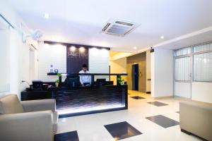 a person standing in a lobby with a counter at Sanctum Suites Indiranagar Bangalore in Bangalore