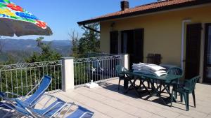 patio ze stołem, krzesłami i parasolem w obiekcie Cinque Terre Tra Il Filo Di Arianna w mieście Riccò del Golfo di Spezia