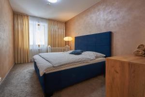 a bedroom with a blue bed with a blue headboard at Donovaly Residence Apartment 111 in Donovaly
