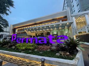 Um edifício com um sinal roxo à frente. em Hotel Permata Bogor em Bogor