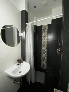 a bathroom with a sink and a mirror and a shower at 555 метров до моря in Liepāja