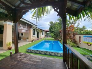 vistas a la piscina desde el porche de una casa en Achutra Muslim Guesthouse (pool) en Melaka