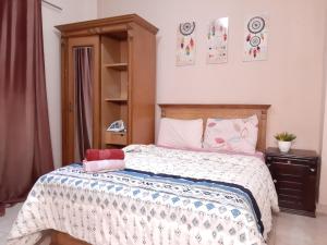 Schlafzimmer mit einem Bett mit einer weißen und blauen Bettdecke in der Unterkunft Family Apartment - Downtown Cairo in Kairo