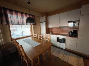 cocina con mesa de madera, mesa y sillas en Viihtyisä lomahuoneisto Rukalla!, en Kuusamo