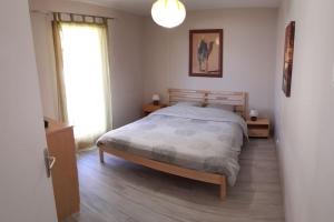 ein Schlafzimmer mit einem Bett und einem großen Fenster in der Unterkunft Charmant Appartement Lac d'Annecy / Ski - 6 Pers in Menthon-Saint-Bernard