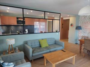 ein Wohnzimmer mit einem blauen Sofa und einem Tisch in der Unterkunft Charmant Appartement Lac d'Annecy / Ski - 6 Pers in Menthon-Saint-Bernard