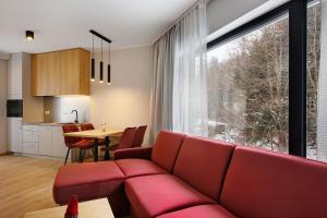 salon z czerwoną kanapą i stołem w obiekcie PARK APARTAMENTY Krynica Zdrój w mieście Krynica Zdrój