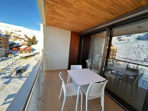 a balcony with a table and chairs and a view at Le Marlou in La Toussuire