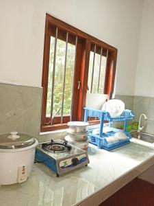 a kitchen counter with a stove and a window at Maneesha Guest House in Weligama