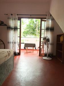 a bedroom with a bed and a sliding glass door at Maneesha Guest House in Weligama