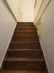 - un escalier avec des marches en bois dans un bâtiment dans l'établissement Maison d'hôtes du Faubourg Charrault Saint Maixent L'Ecole, à Saint-Martin-de-Saint-Maixent