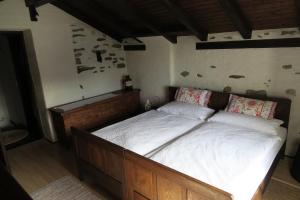 a bedroom with a large bed with white sheets at Rustico Storelli in Brissago