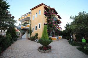 a building with flowers on the side of it at Flower Garden Villa in Ksamil