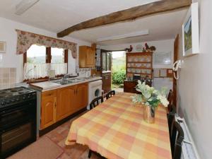 a kitchen with a table and a stove top oven at The Granary Ruthwaite in Uldale