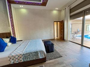 1 dormitorio con cama y vistas a la piscina en Agafay villa, en Marrakech