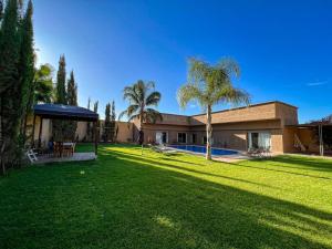 una casa con un patio con piscina y palmeras en Agafay villa, en Marrakech