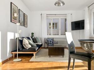 ein Wohnzimmer mit einem Sofa und einem Stuhl in der Unterkunft Alpenzauber Suite für vier in Thun