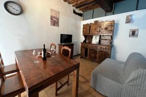 Cette chambre comprend une table avec des verres à vin et une horloge. dans l'établissement L'angolo del Barbacane, à Terricciola