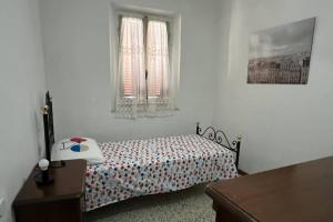 - une chambre blanche avec un lit et une fenêtre dans l'établissement L'angolo del Barbacane, à Terricciola