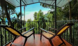 two chairs on a balcony with a view of the jungle at Arana Sri Lanka Eco Lodge and Yoga Center in Ella