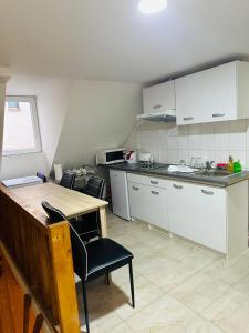Ubytování u Tranů في فرتشلابي: مطبخ مع دواليب بيضاء وطاولة وكراسي