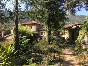 a stone house in the middle of a garden at L'abri la Vall in Sorède