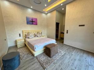 ein Schlafzimmer mit einem Bett und einer Ottomane in der Unterkunft agafay villa in Marrakesch