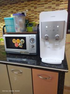 a counter with a coffee maker and a microwave at D' SHAM Homestay, Mslim Only in Kulim
