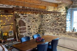 a dining room with a wooden table and chairs at Maison La Pierre du Lézard Nature Auvergne-Rhône-Alpes in Laurie