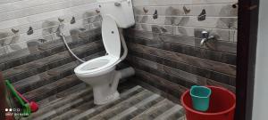 uma casa de banho com um WC numa parede de tijolos em Vyshnavi home stay em Thanniyam