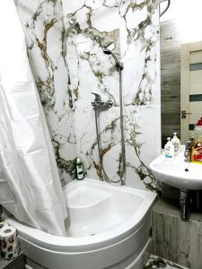 een badkamer met een bad, een toilet en een wastafel bij Smart Apartment in Chişinău
