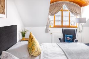 a bedroom with a bed and a chair and a window at Hotel Baroko in Prague