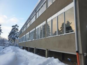 um edifício com muitas janelas na neve em The old school motell & lägenheter em Marma