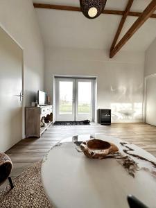 ein Wohnzimmer mit einem großen weißen Zimmer mit einem Tisch in der Unterkunft The Smiling Buddha in Achthuizen