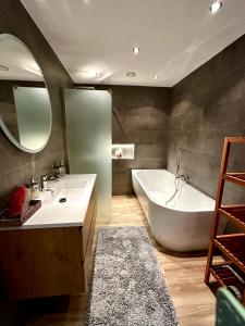 een badkamer met een bad, een wastafel en een bad bij The Smiling Buddha in Achthuizen