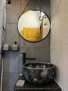 bagno con grande lavandino in pietra e specchio di Cottages Serdar a Mojkovac