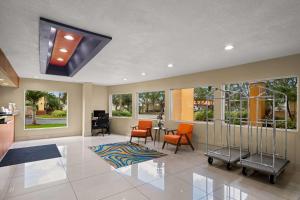 - un salon avec une table, des chaises et des fenêtres dans l'établissement Quality Inn Sarasota I-75, à Sarasota