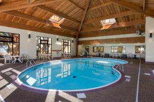 uma piscina num quarto grande com tecto em madeira em Comfort Inn & Suites Branson Meadows em Branson