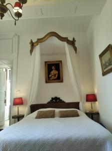 a bedroom with a white bed with a framed mirror at Le Logis de Saint Cyr in Issoudun