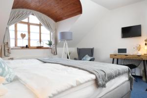 a bedroom with a bed and a desk and a window at Hotel Baroko in Prague