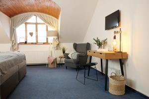 a bedroom with a bed and a desk and a chair at Hotel Baroko in Prague