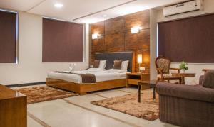 um quarto com uma cama, uma secretária e um sofá em Athasri Hotel Infantry Road em Bangalore