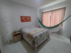 a bedroom with a bed and a hammock in it at Lar das Cerejeiras in Bananeiras