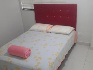 ein Schlafzimmer mit einem Bett mit einer rosa Rolle darauf in der Unterkunft VS HOSPEDAGEM in Cascavel